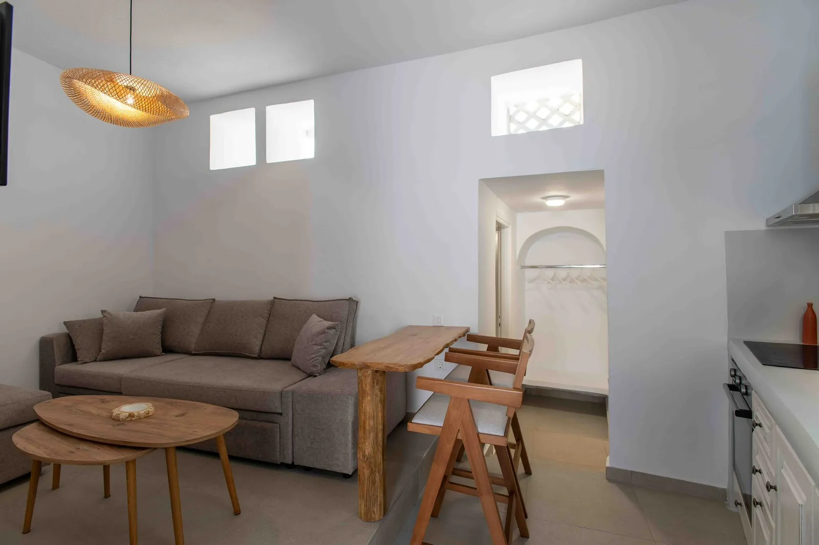 Living room with sofa bed, woven pendant light and dining bar