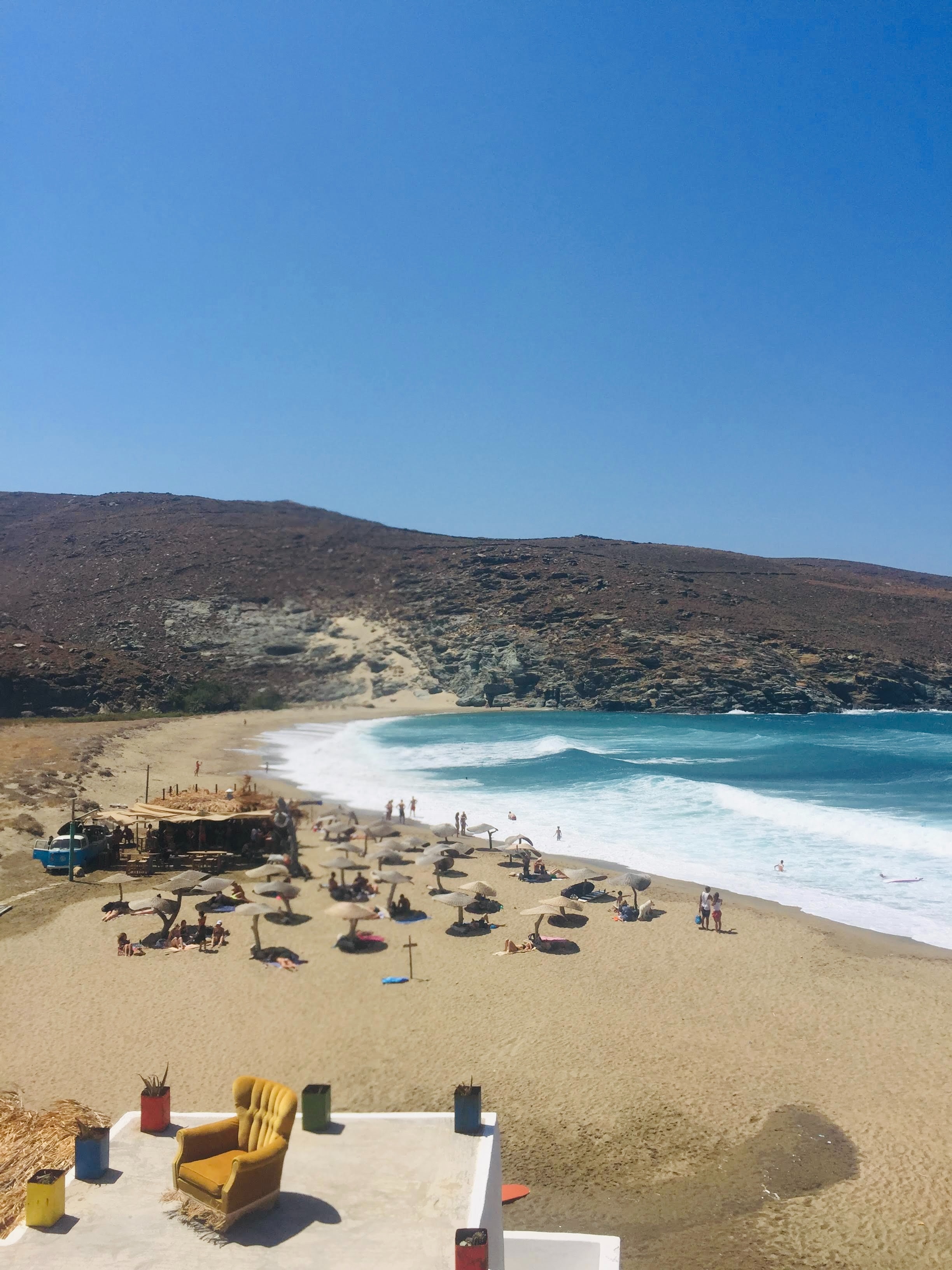 Kolymbithra beach in Tinos — golden sand, turquoise waves, straw umbrellas