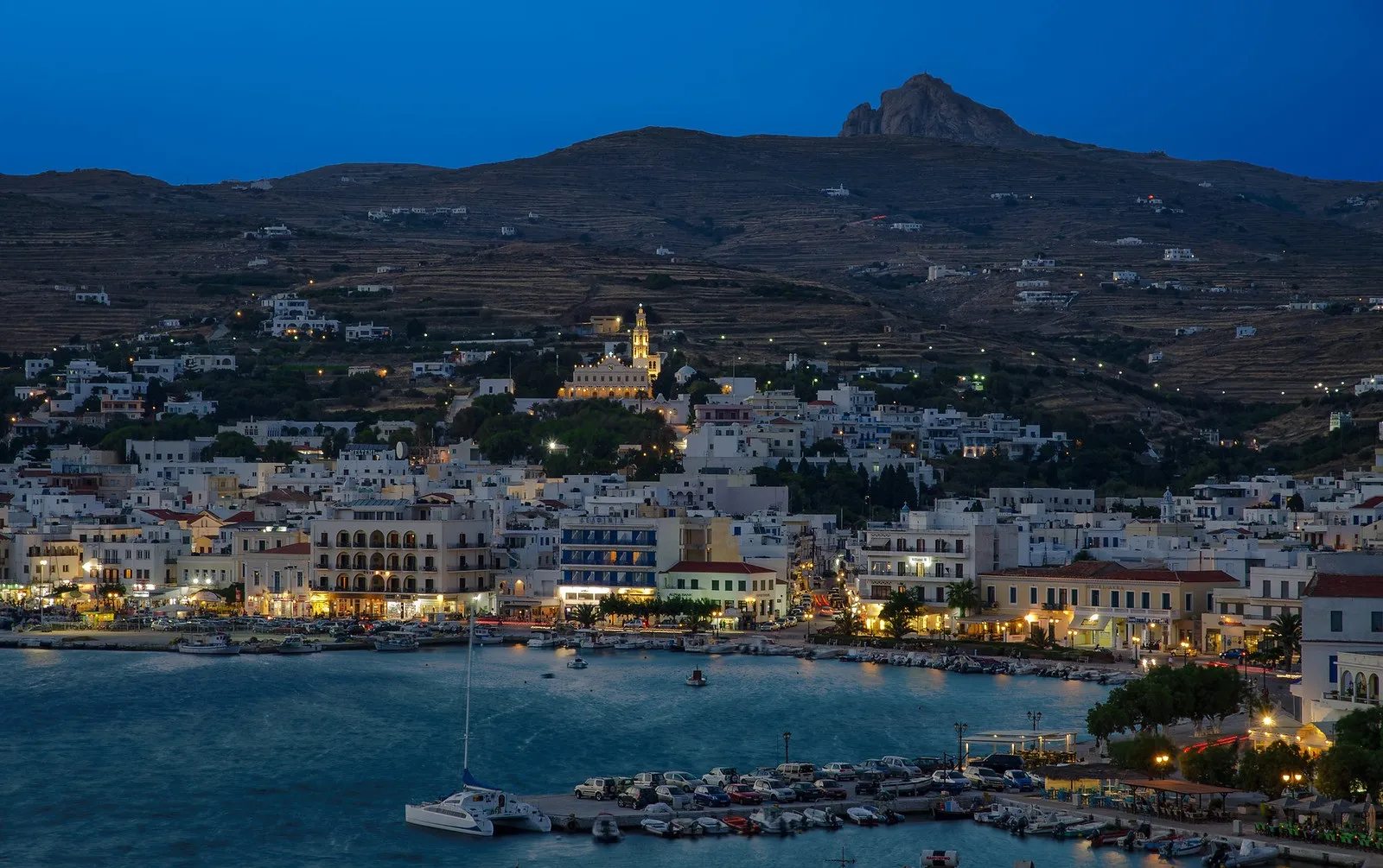 Tinos town illuminated at dusk, viewed from the sea