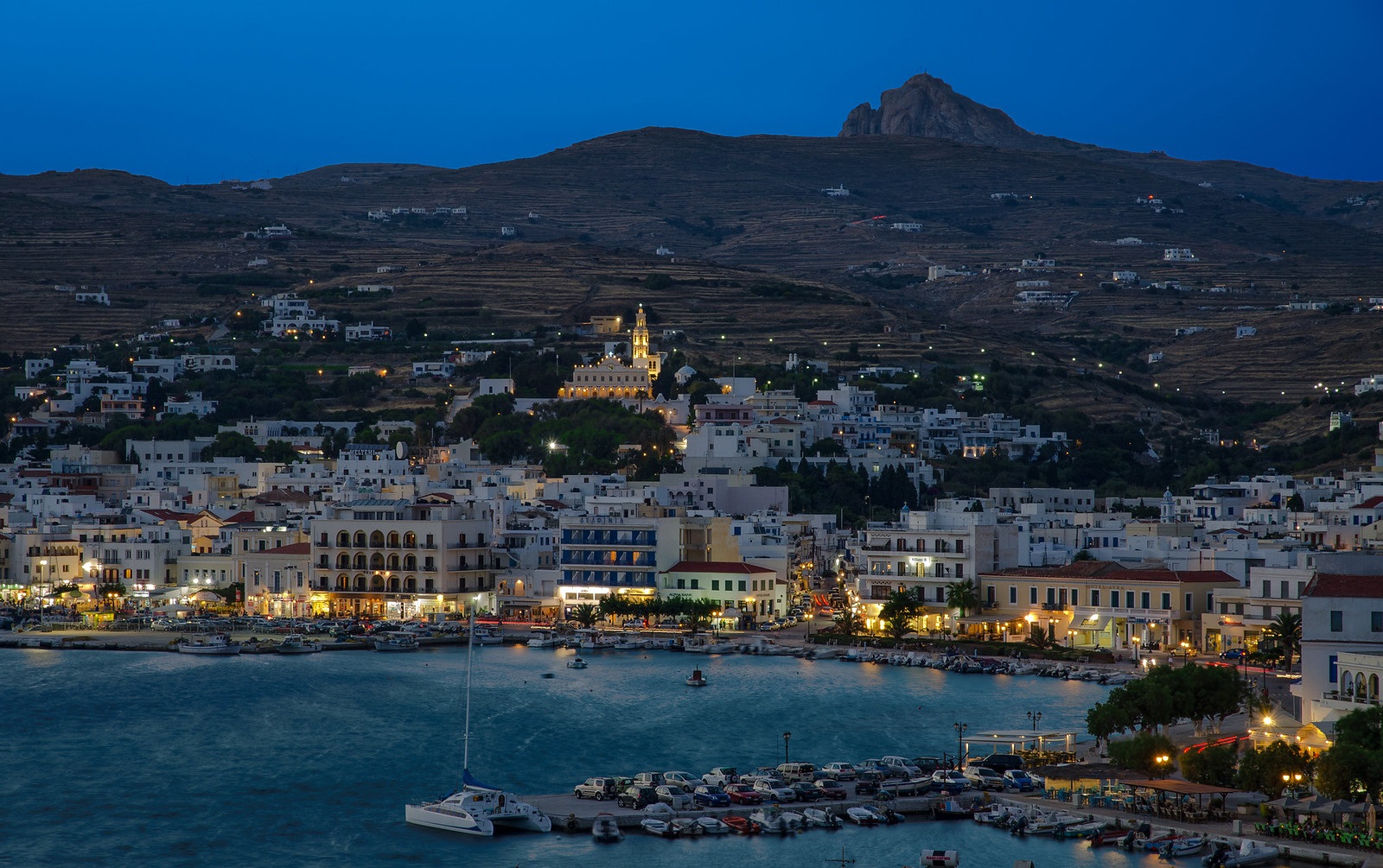 Tinos town illuminated at dusk, viewed from the sea